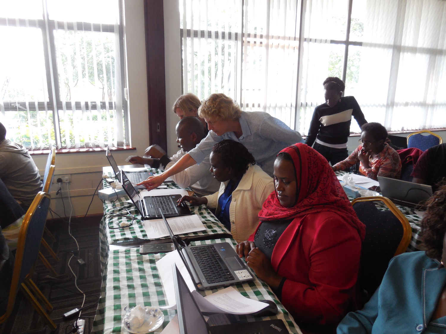 Liz Boyle, IPUMS-DHS, and Agnes Muthoni Linus, Kenya Medical Training College, troubleshoot a problem, while Zaineb Gura, Kenya Ministry of Health, works independently (photo by Matt Sobek).