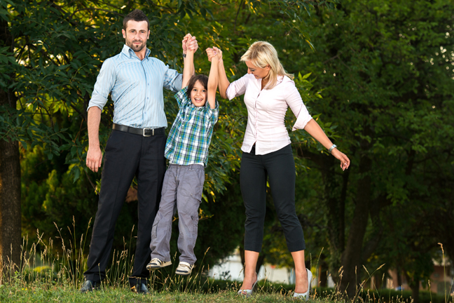 Happy parents lifting their smiling son by hands