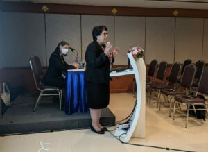 Jane standing at podium while speaking