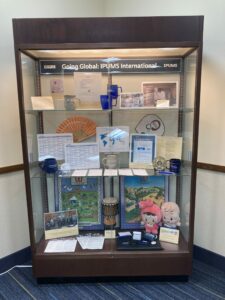 Display case with a banner "Going Global: IPUMS International" and memorabilia from around the world 