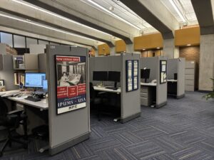 Four cubicles in a row with historical census posters hanging up in between